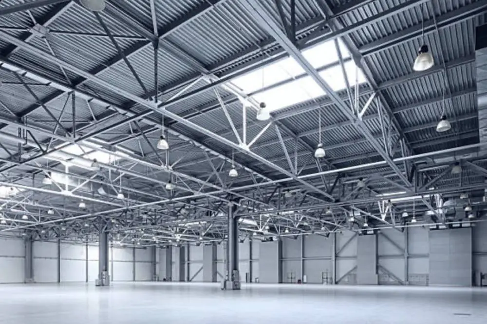 A large warehouse with lots of lights and a ceiling.